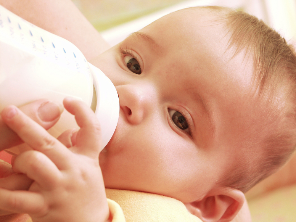Baby drinking bottle close up