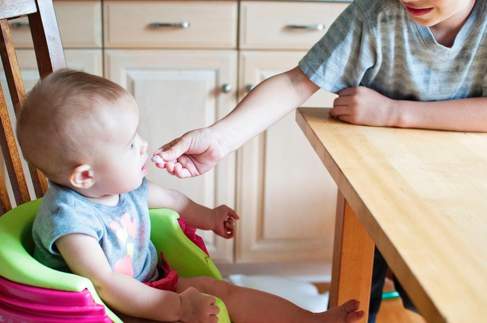 Baby eating in booster chair