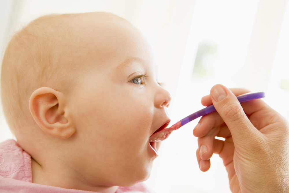 Mother feeding baby food