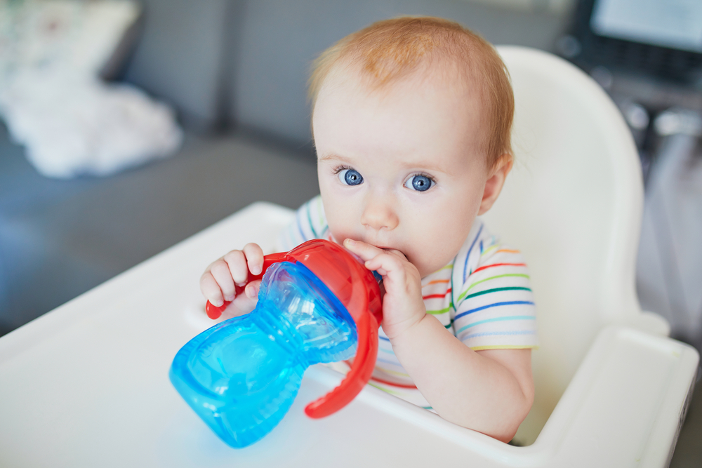 Baby in highchair with sippy cup